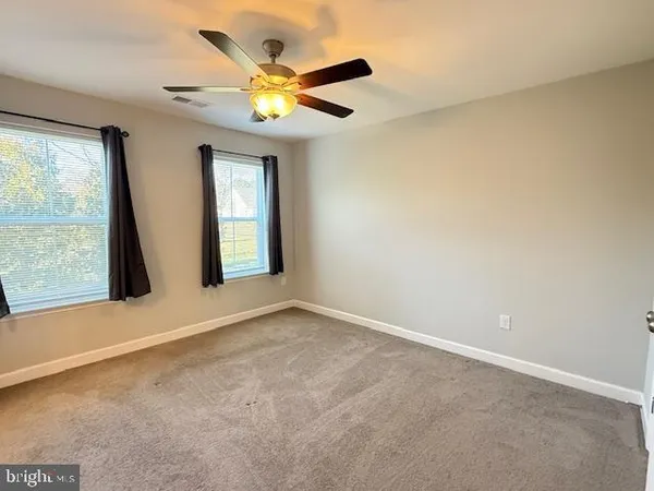 an empty room with a window and a ceiling fan
