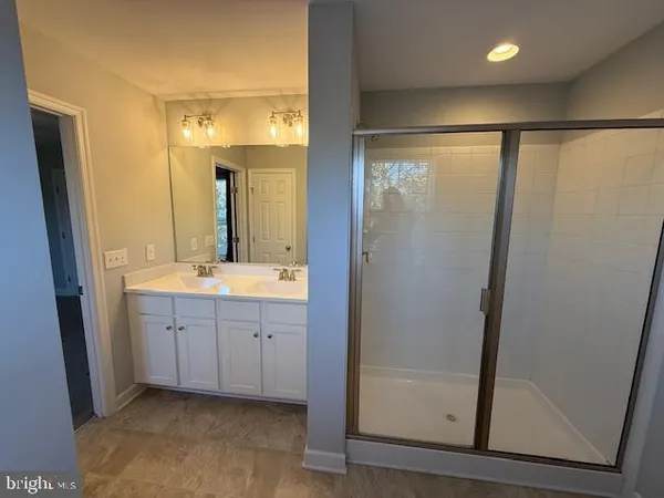 a bathroom with a glass shower door and a sink