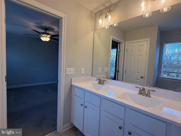 a bathroom with a double vanity sink and a mirror