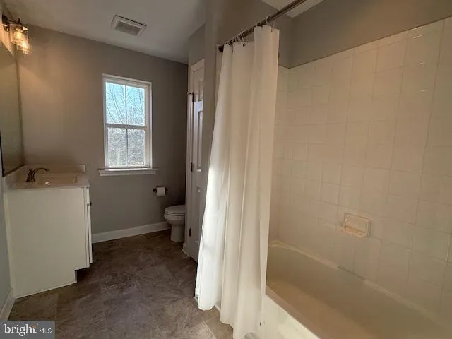 a bathroom with a sink toilet and window