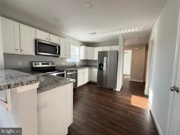 a kitchen with stainless steel appliances granite countertop a refrigerator stove microwave and sink