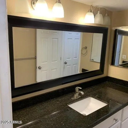 a kitchen with stainless steel appliances granite countertop a refrigerator a microwave oven a sink with dishwasher and white cabinets