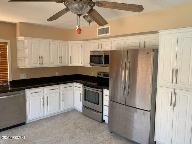 1514 East Weathervane Lane Tempe, AZ 85283 - Photo 8 of 18 a kitchen with stainless steel appliances granite countertop a refrigerator a microwave oven a sink with dishwasher and white cabinets