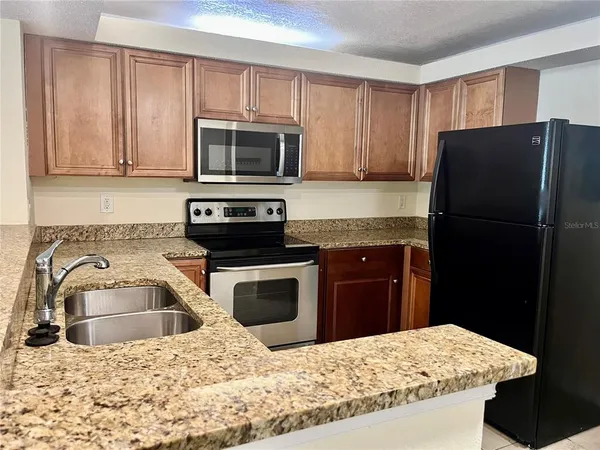a kitchen with a sink stove and refrigerator