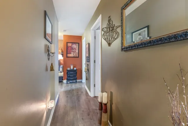 a view of a hallway with wooden floor and staircase