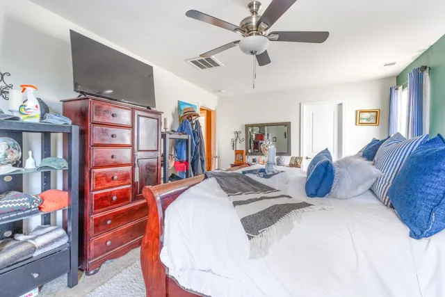 a large bedroom with a bed and flat screen tv