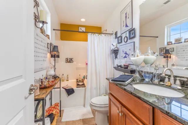 a bathroom with a granite countertop sink a toilet and shower