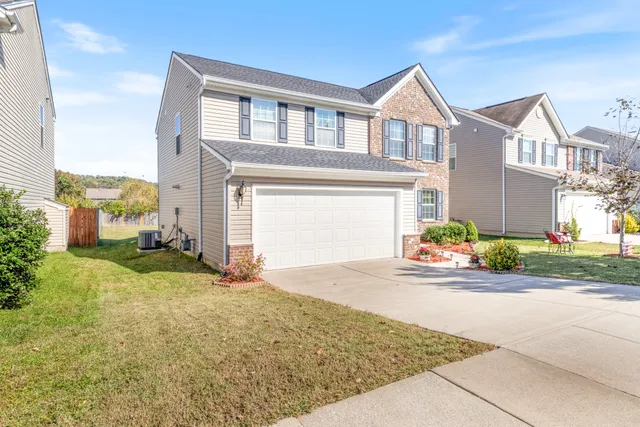 a front view of a house with a yard and garage