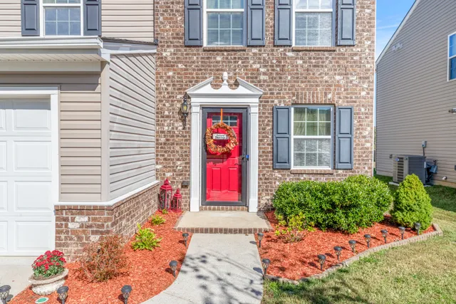 front view of a brick house with a yard
