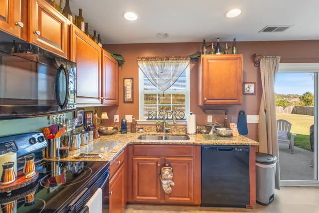 a kitchen with stainless steel appliances granite countertop a sink stove and cabinets