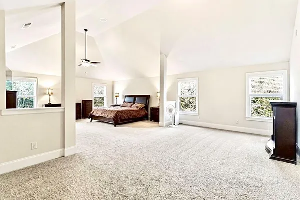 a spacious bedroom with a bed dresser and a ceiling fan