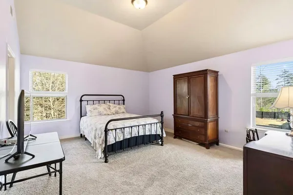 a bedroom with a bed and a flat tv screen on dresser