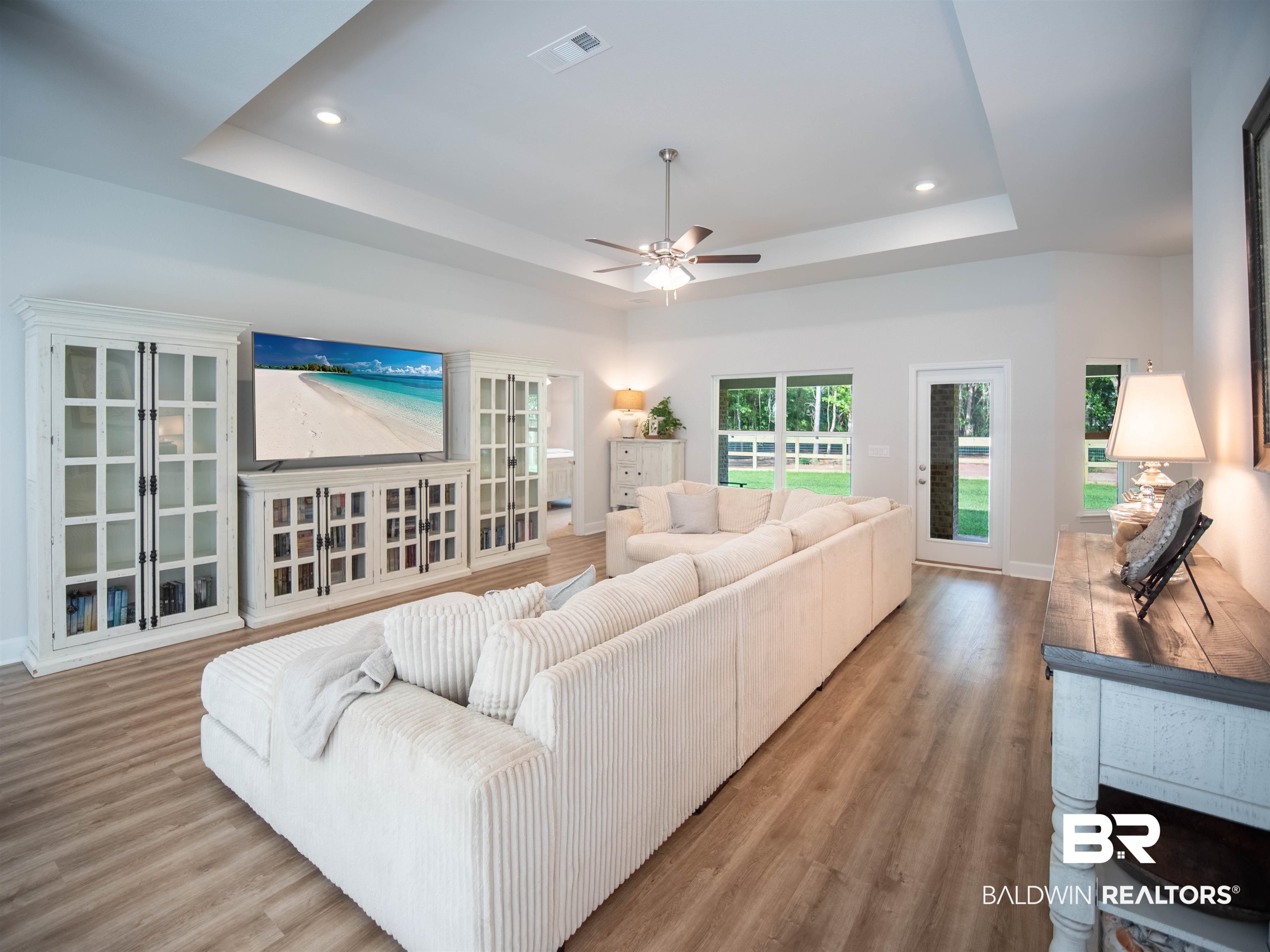 12646 Michigan Avenue Elberta, AL 36530 - Photo 6 of 47 Living room featuring a tray ceiling, wood finished floors, a ceiling fan, and recessed lighting