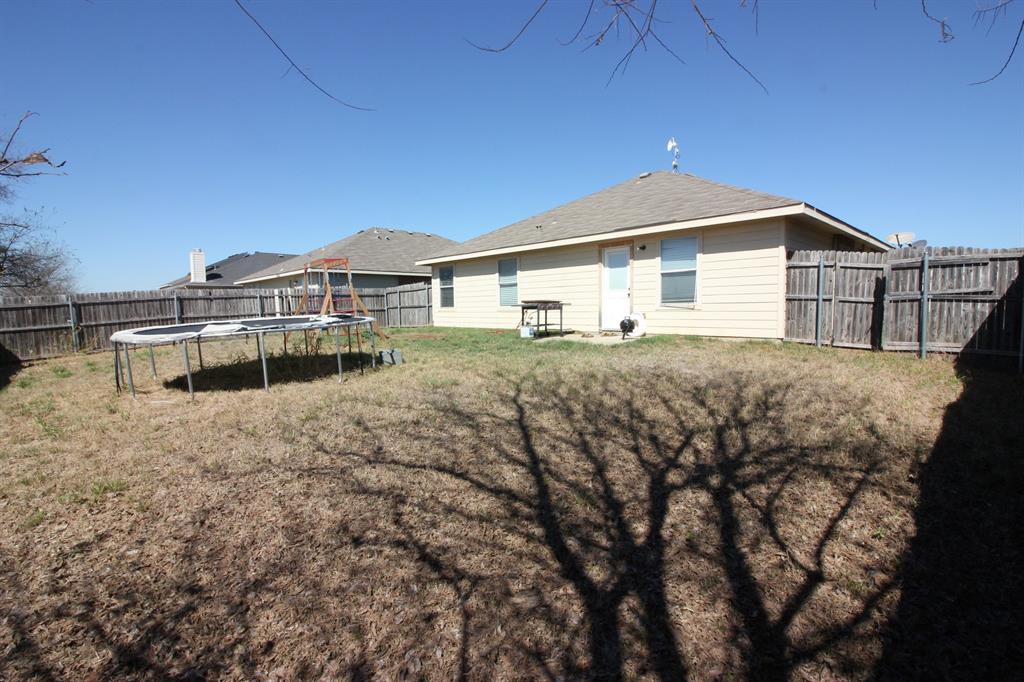 12609 Carpenter Lane Rhome, TX 76078 - Photo 26 of 29 Expansive backyard featuring a wood privacy fence, concrete patio, and neutral-toned siding