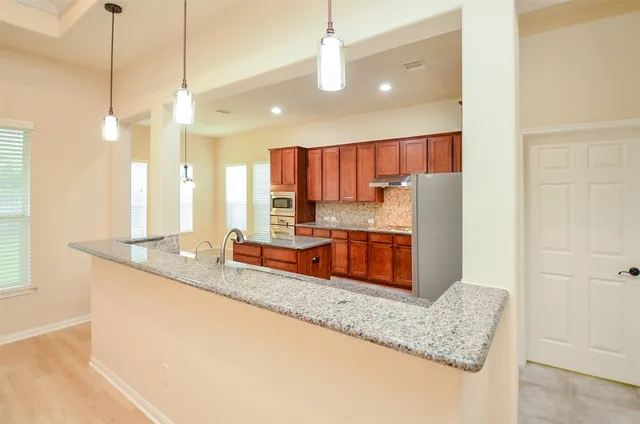 a kitchen with stainless steel appliances granite countertop a refrigerator and a sink