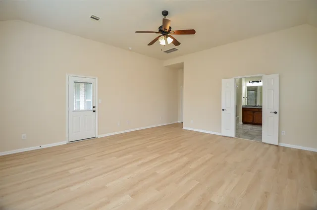 a view of wooden floor and a chandelier fan in a room