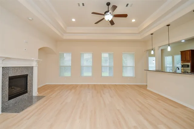 a view of an empty room with a fireplace and a window