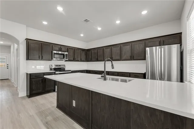 a kitchen with stainless steel appliances granite countertop a sink stove and refrigerator