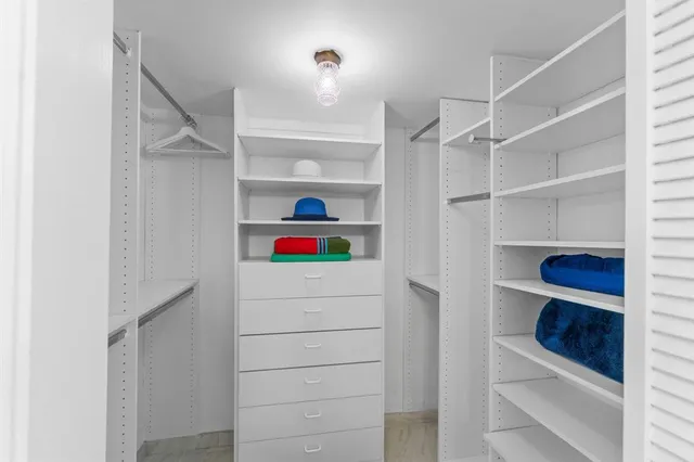 a view of walk in closet with empty racks