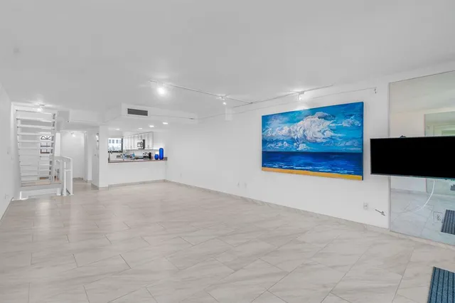 a view of an empty room with a painting on the wall