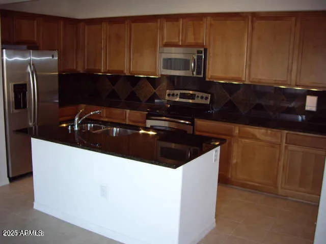 a kitchen with granite countertop a sink and a stove