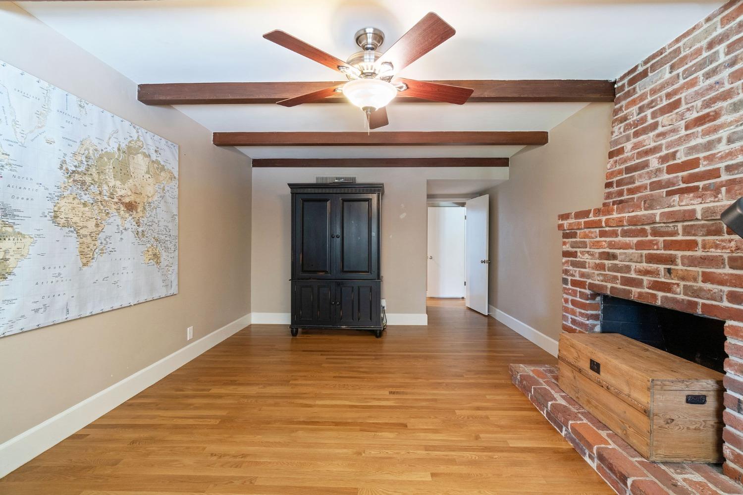 1323 West San Ramon Avenue Fresno, CA 93711 - Photo 11 of 30 a view of an empty room with a fireplace and a ceiling fan