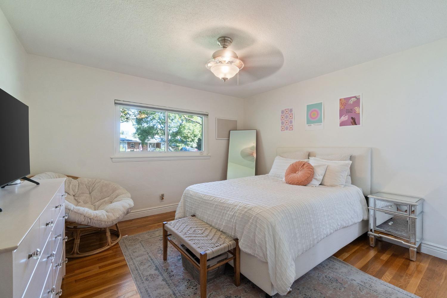 1323 West San Ramon Avenue Fresno, CA 93711 - Photo 16 of 30 a bedroom with a bed and a chandelier