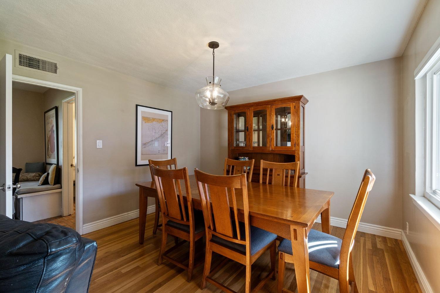 1323 West San Ramon Avenue Fresno, CA 93711 - Photo 18 of 30 a dining room with furniture a chandelier and wooden floor