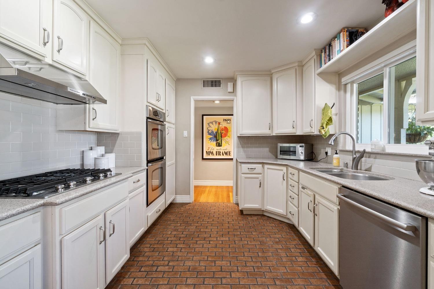 1323 West San Ramon Avenue Fresno, CA 93711 - Photo 8 of 30 a kitchen with stainless steel appliances granite countertop a stove sink and cabinets