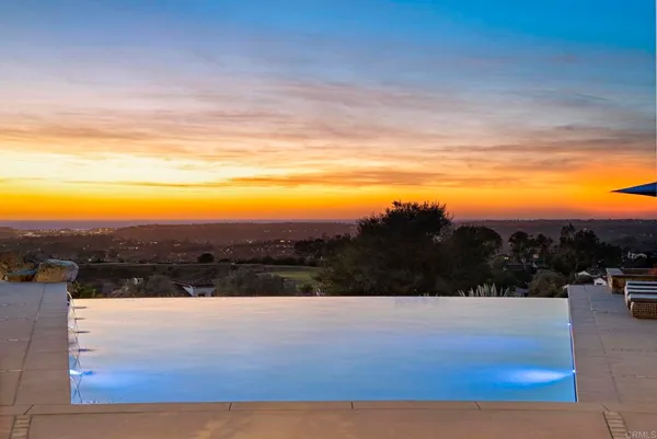 a view of mountain with sunset in background