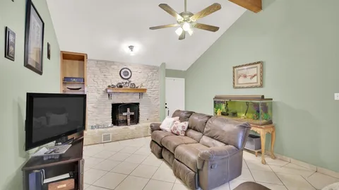 a living room with furniture a flat screen tv and a fireplace