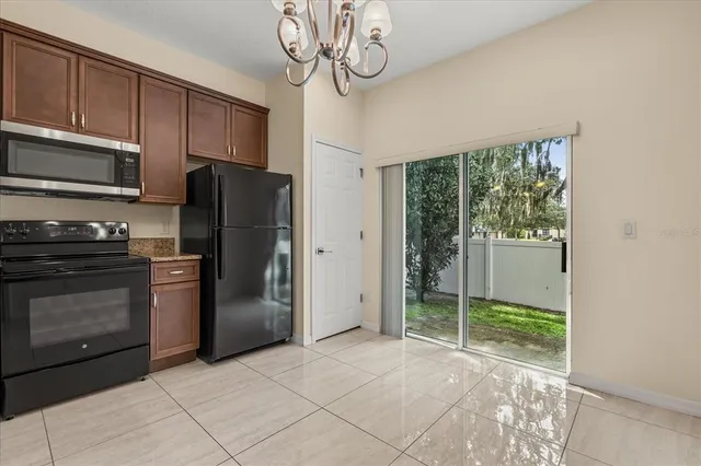 a kitchen with stainless steel appliances granite countertop a refrigerator a stove and a sink