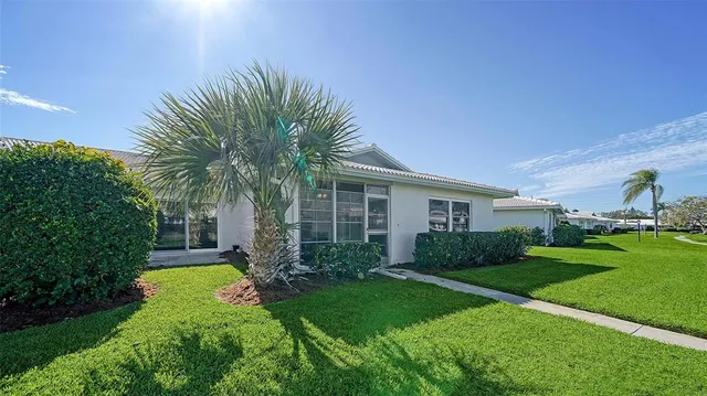 a view of a house with backyard and a tree