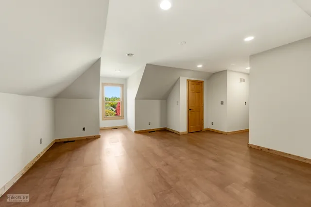 an empty room with wooden floor and window