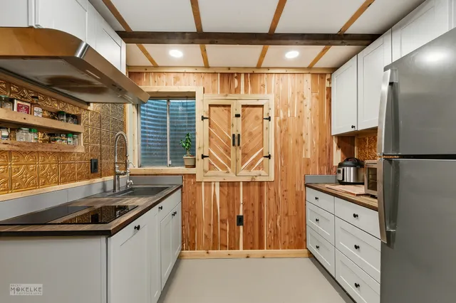 a kitchen with granite countertop a sink and a refrigerator