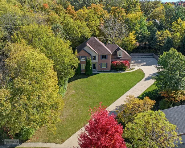 a aerial view of a house next to a yard with large trees