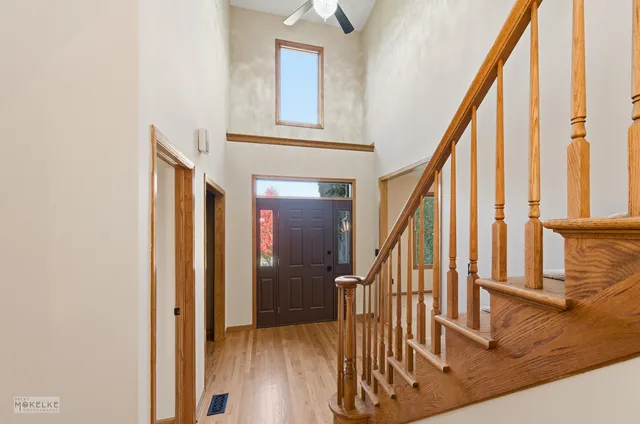 a view of an entryway with wooden floor and door