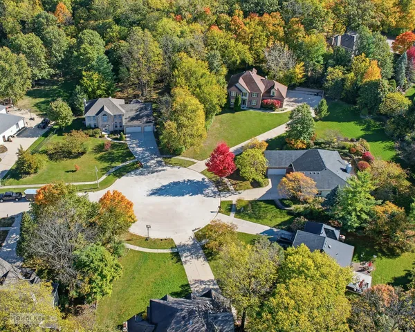an aerial view of a house with a garden and lots of trees