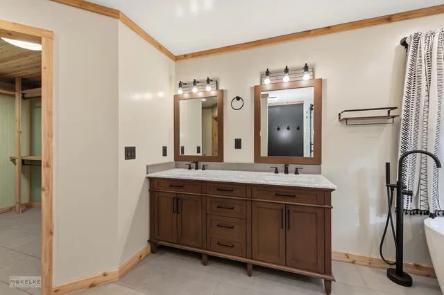 a bathroom with a double vanity sink and a mirror