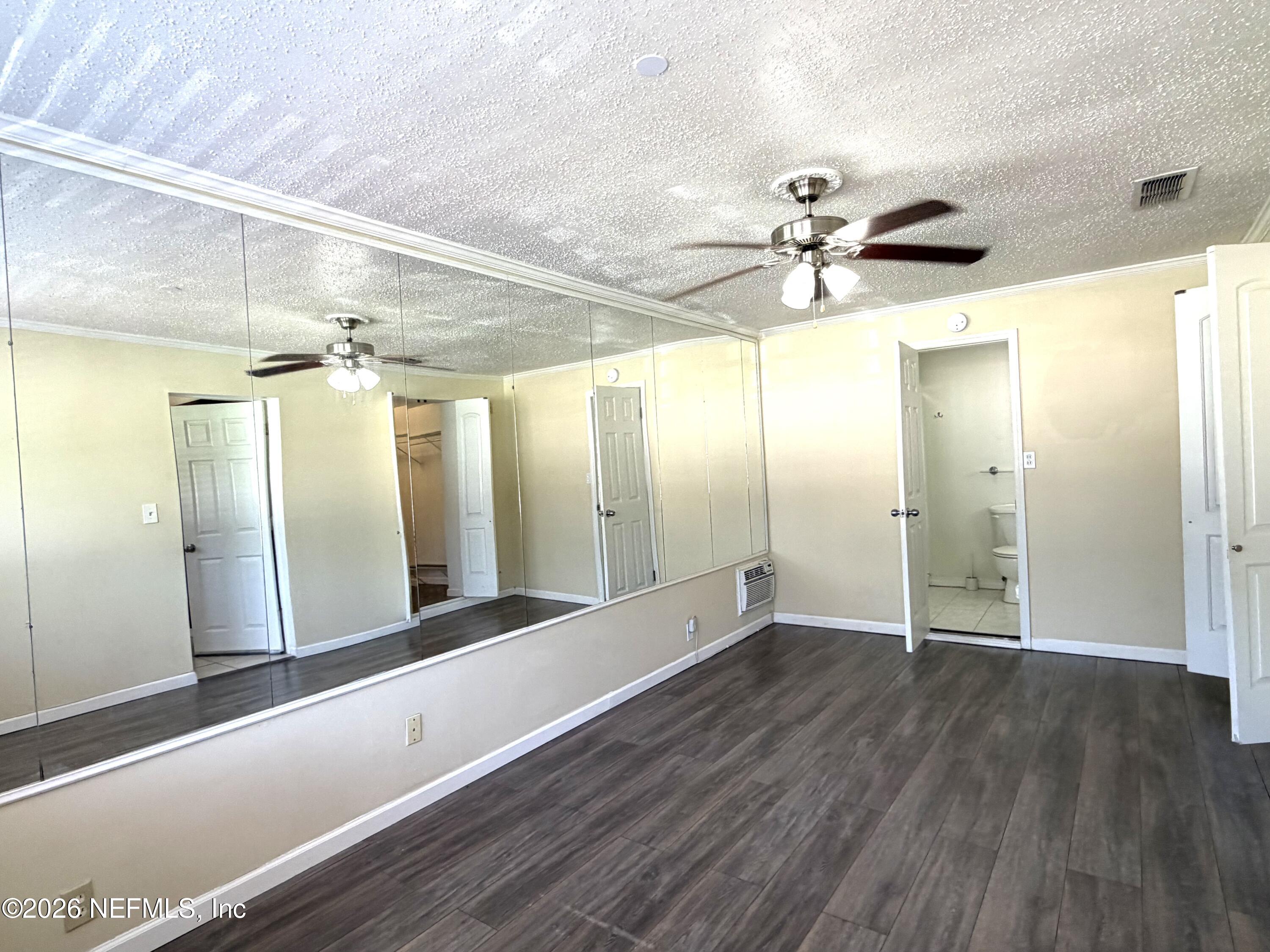 4127 Springwood Road Jacksonville, FL 32207 - Photo 17 of 63 a view of a big room with wooden floor and a ceiling fan