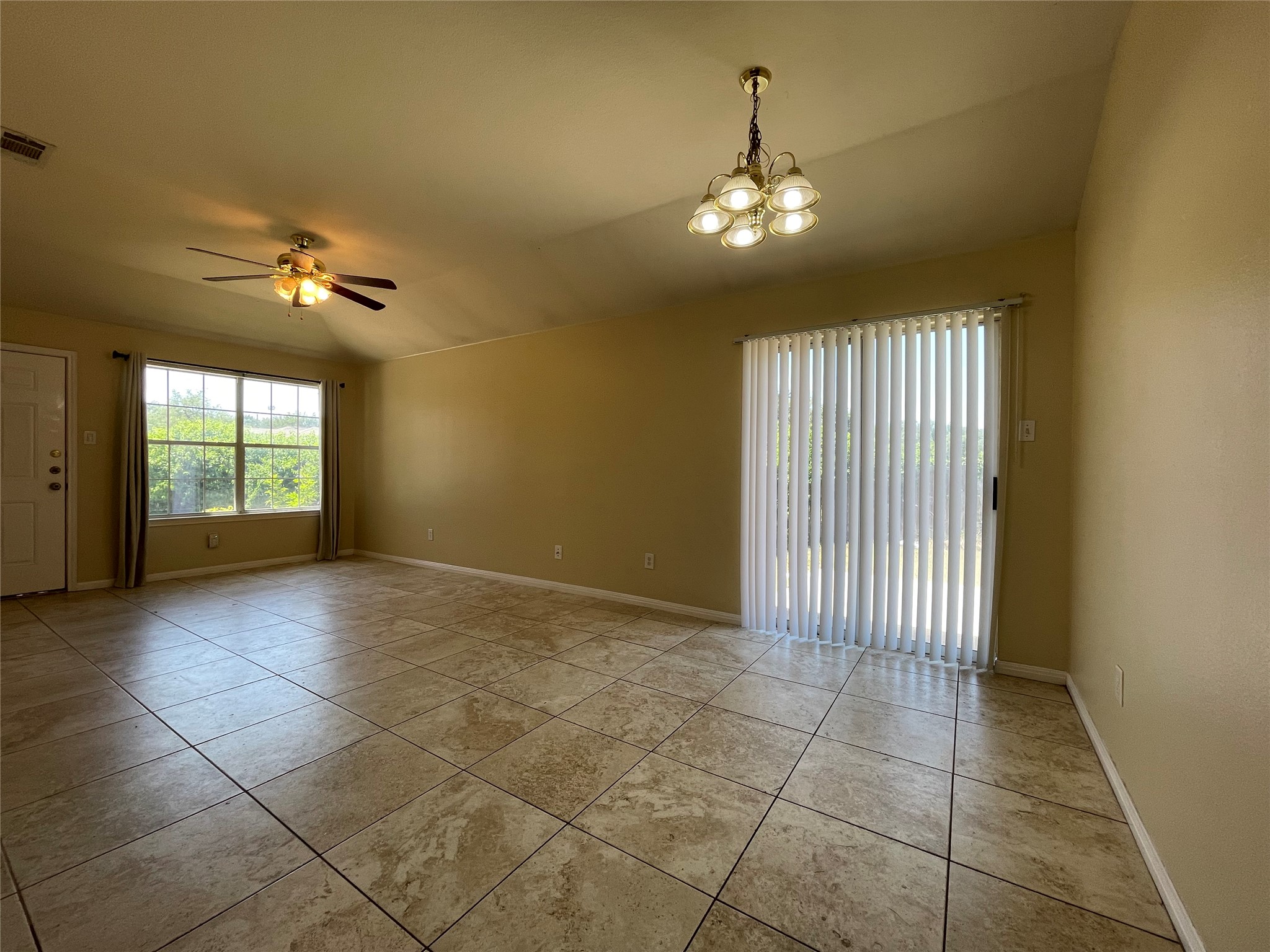 Undisclosed Address Austin, TX 78729 - Photo 3 of 8 Empty room featuring vaulted ceiling, ceiling fan, a chandelier, and light tile patterned floors