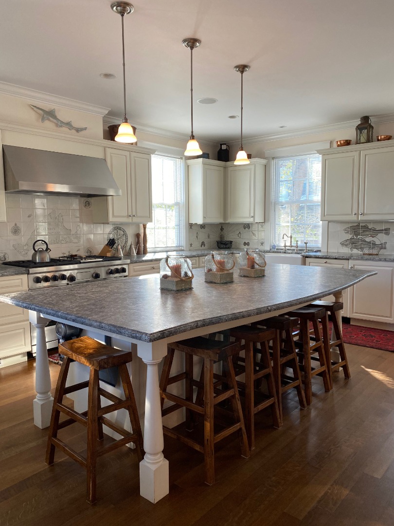 12 Spring Street Vineyard Haven, MA 02568 - Photo 4 of 40 a kitchen with stainless steel appliances granite countertop a table chairs sink and stove top oven