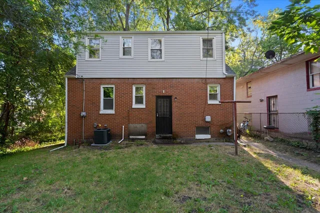 a backyard of a house with potted plants and a large tree