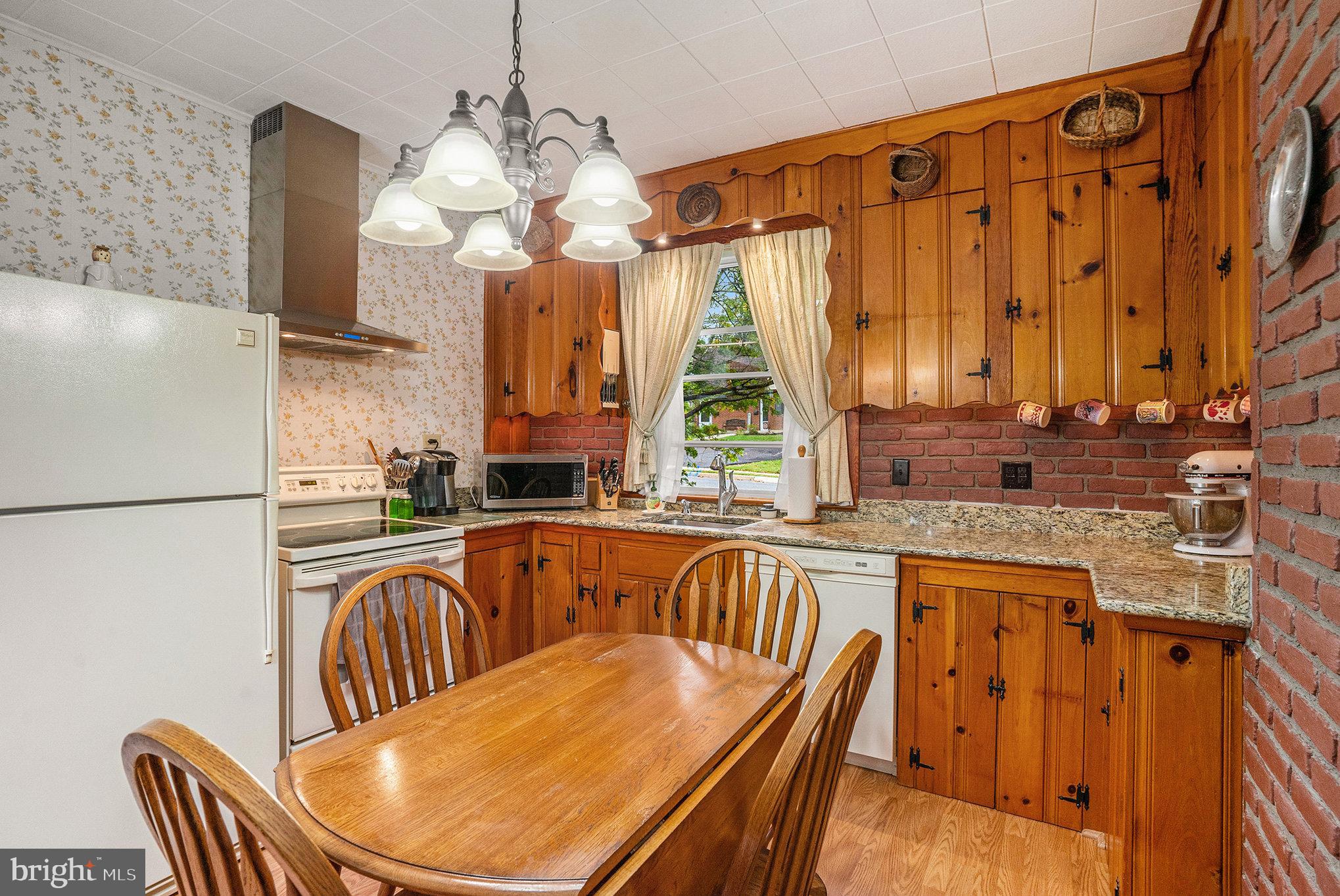 1640 Walnut Avenue Oreland, PA 19075 - Photo 16 of 45 a kitchen with stainless steel appliances granite countertop a sink dishwasher a refrigerator with a dining table and chairs