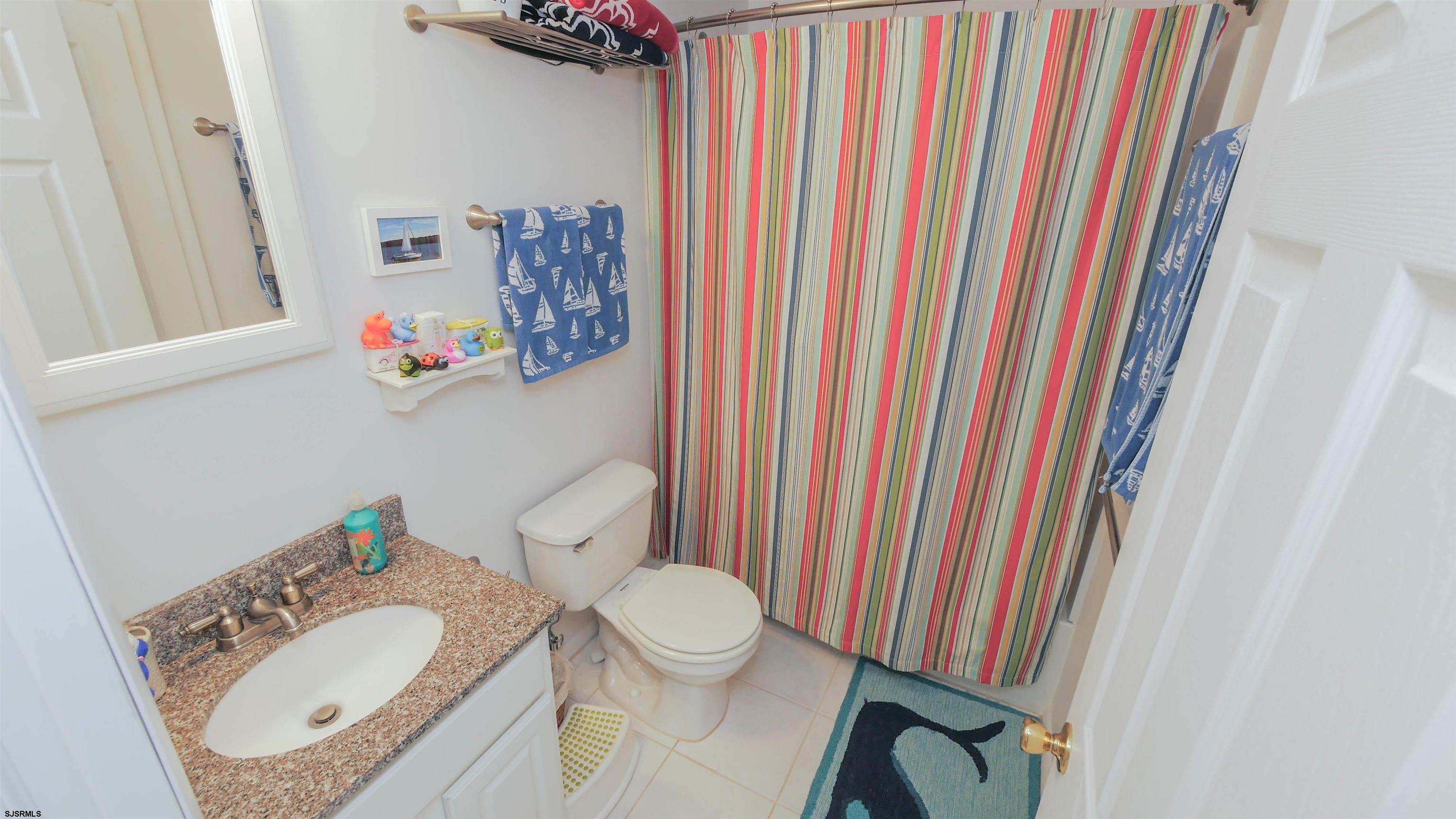 1000 West Brigantine Avenue, Unit 4 Brigantine, NJ 08203 - Photo 11 of 19 a bathroom with a granite countertop sink and a mirror