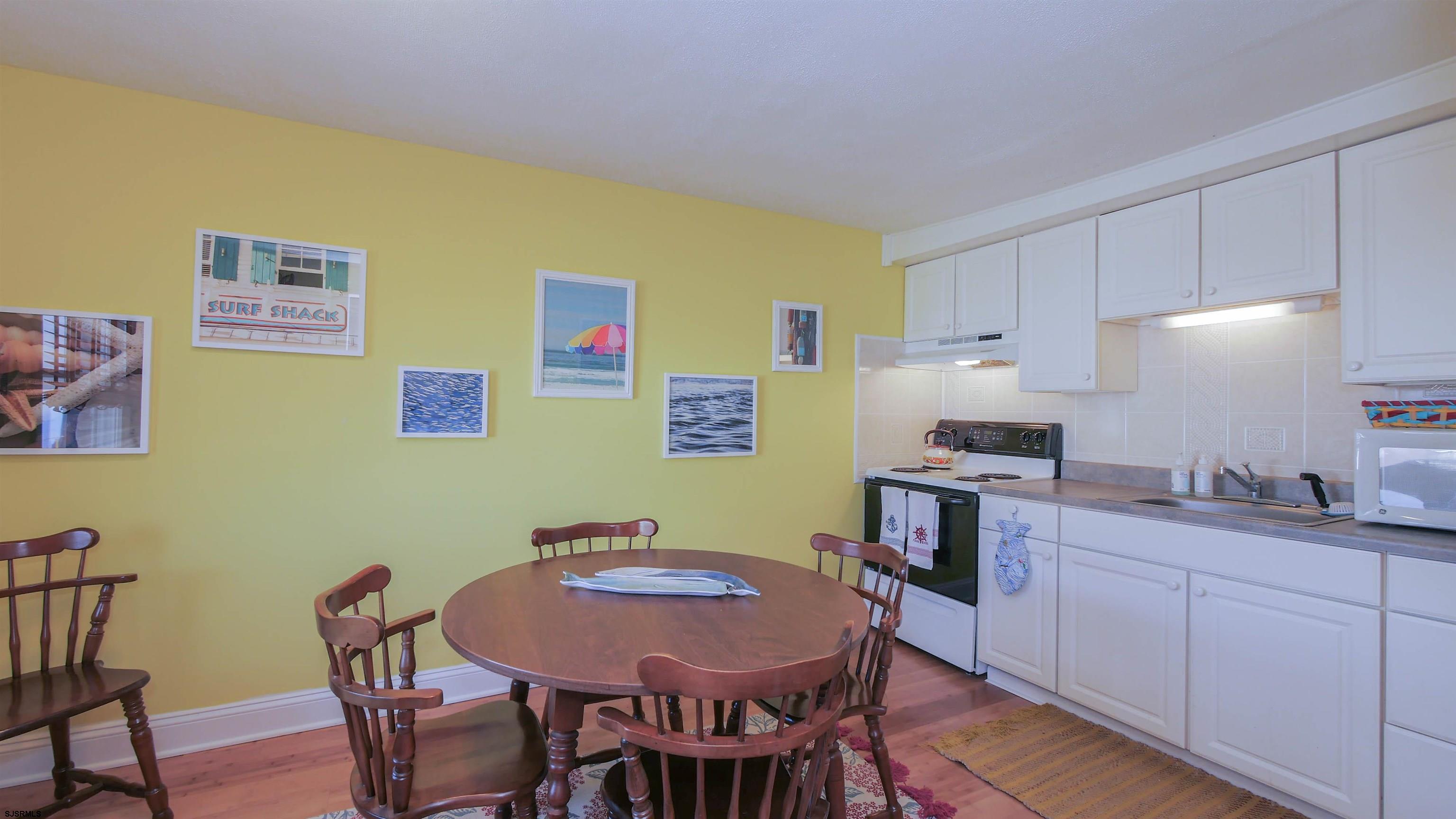 1000 West Brigantine Avenue, Unit 4 Brigantine, NJ 08203 - Photo 6 of 19 a view of a dining room with furniture and wooden floor