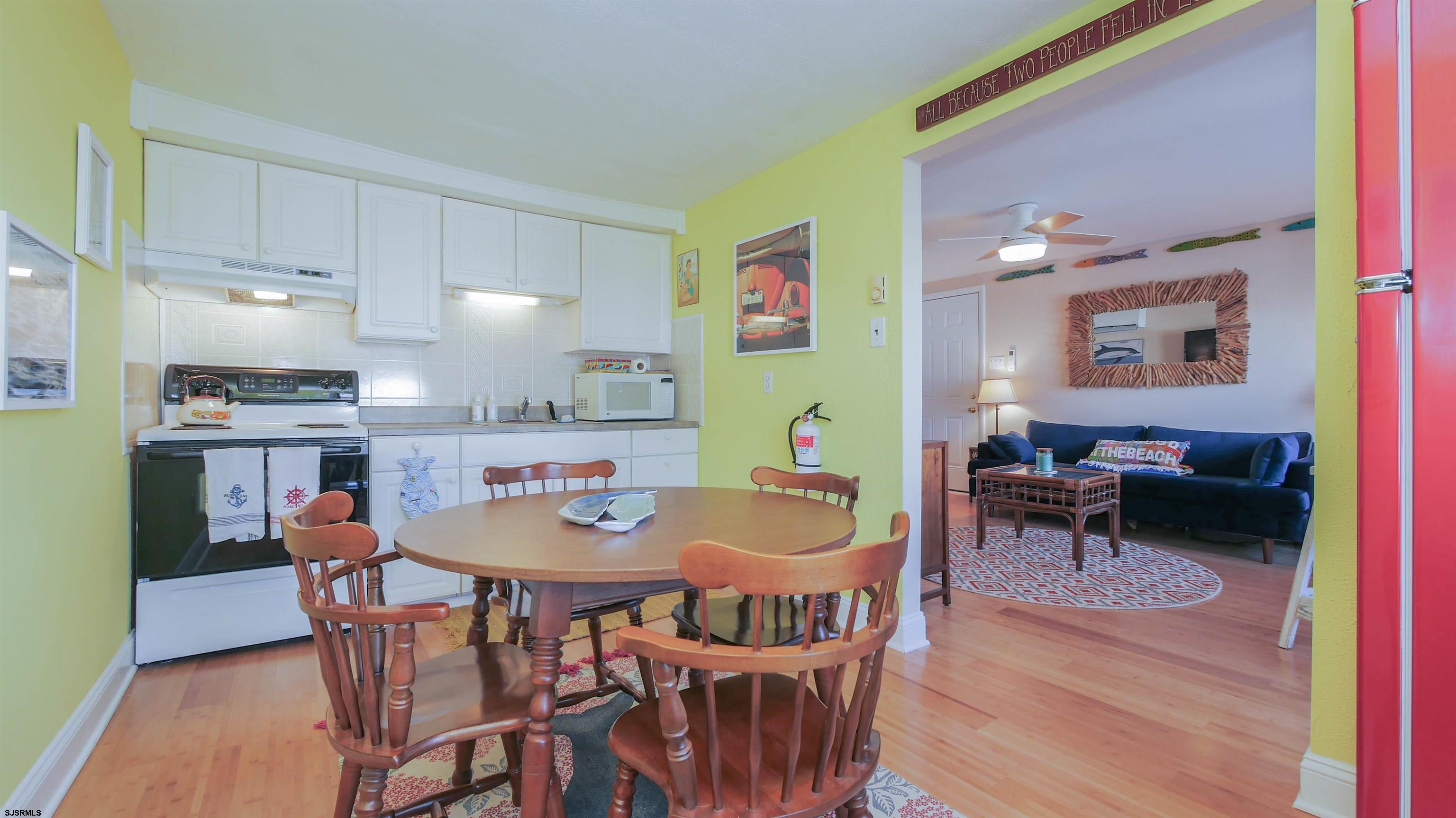 1000 West Brigantine Avenue, Unit 4 Brigantine, NJ 08203 - Photo 7 of 19 a view of a dining room with furniture and wooden floor