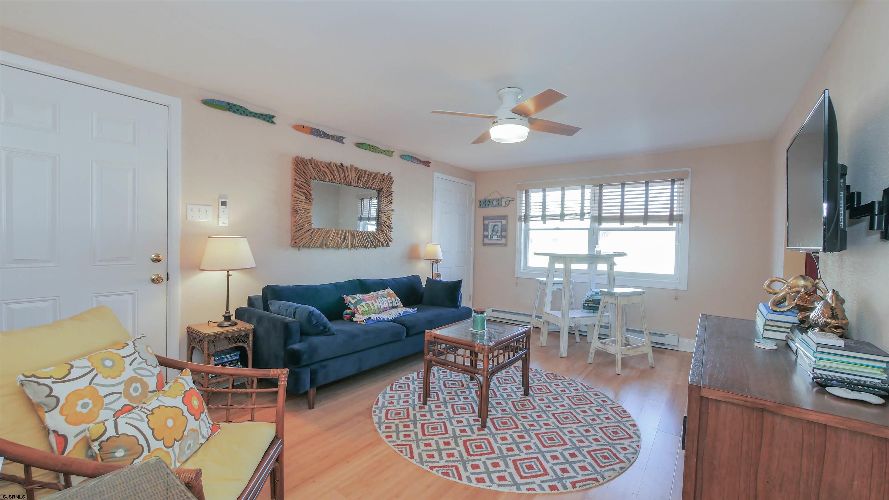 1000 West Brigantine Avenue, Unit 4 Brigantine, NJ 08203 - Photo 10 of 19 a living room with furniture a flat screen tv and a large window
