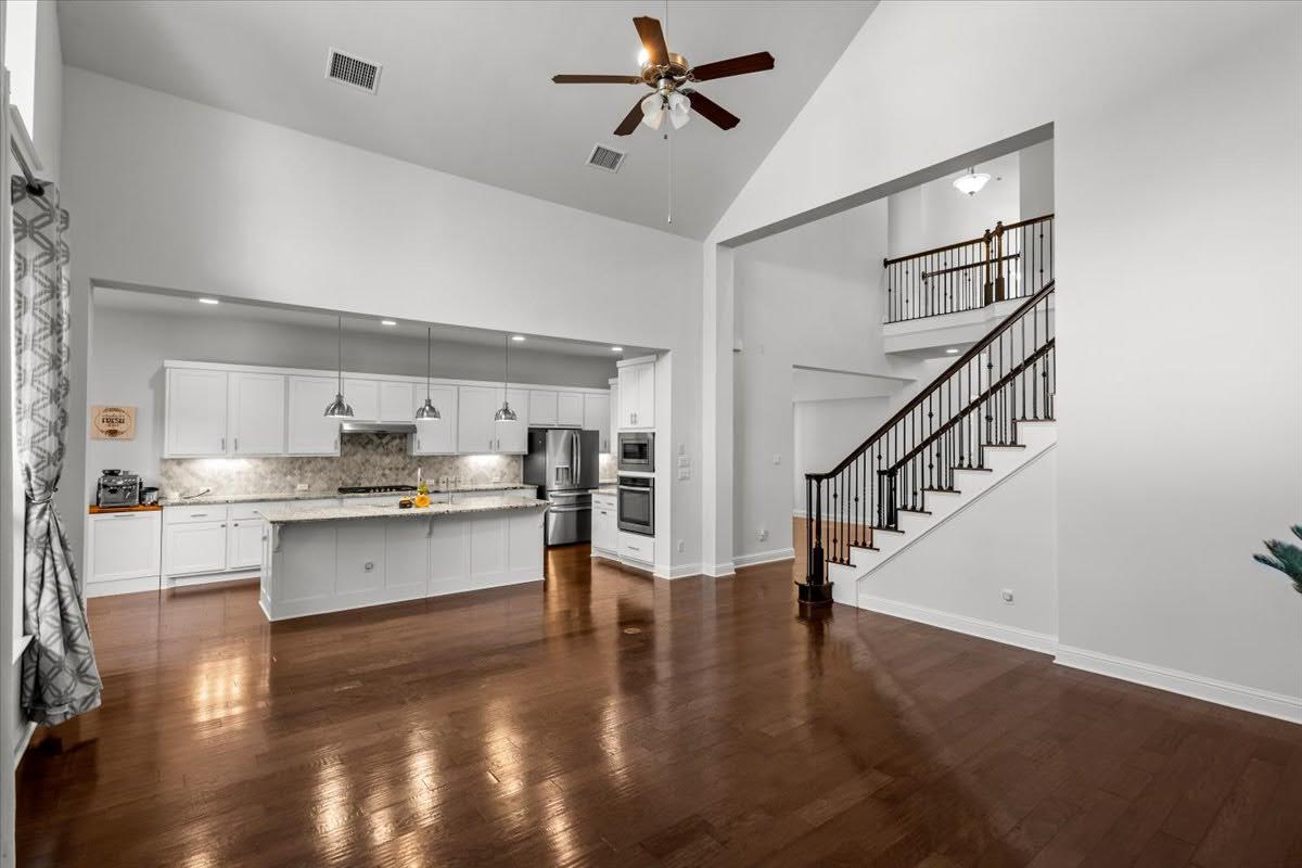 4108 Bison Bend, Unit FOR RENT Cedar Park, TX 78613 - Photo 4 of 36 Elegant hardwood flooring extends throughout this luminous open-concept living space, featuring a chef's kitchen and a grand staircase.