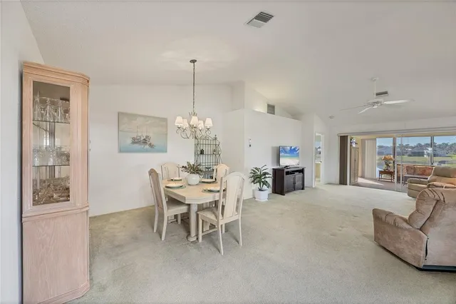 a living room with furniture a chandelier and a floor to ceiling window